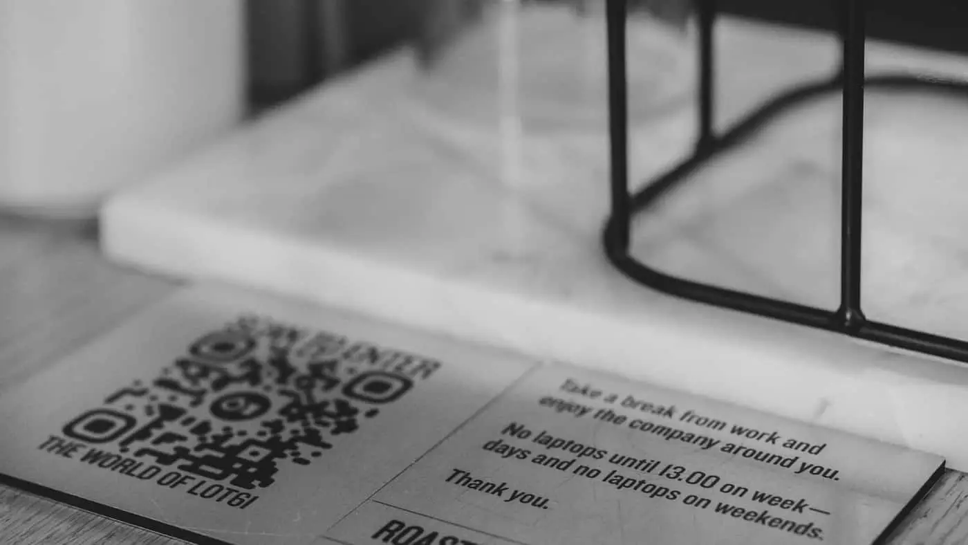 Código QR impreso en la mesa de una cafetería junto a la información del local